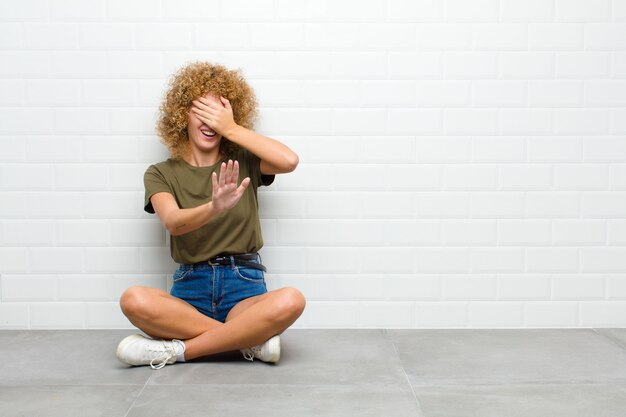 Photo covering face with hand and putting other hand up front to stop camera, refusing photos or pictures