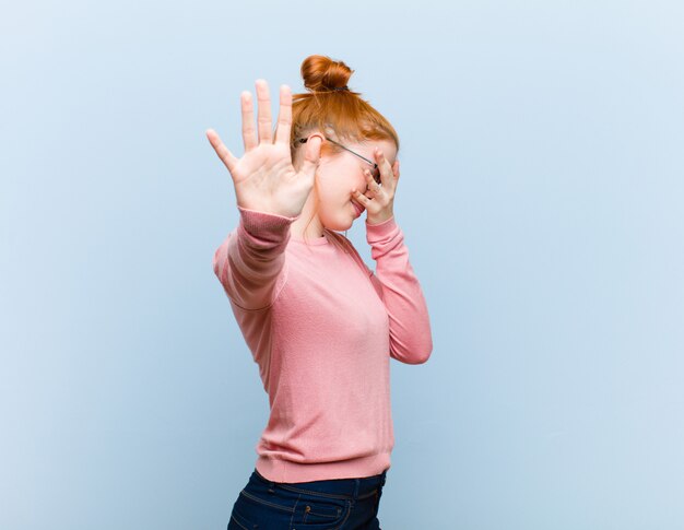 covering face with hand and putting other hand up front to stop, refusing photos or pictures