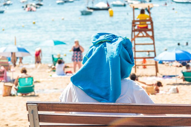 Covering his head with a towel from the sun