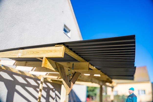 Covering the roof on wooden beams for a gazebo the background of a blue sky