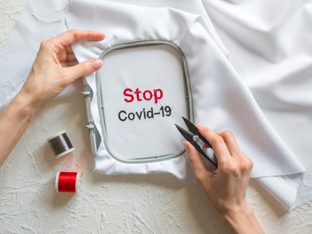 Covid-19 안티 코로나 바이러스 창의적인 개념. 단어는 흰 천에 자수