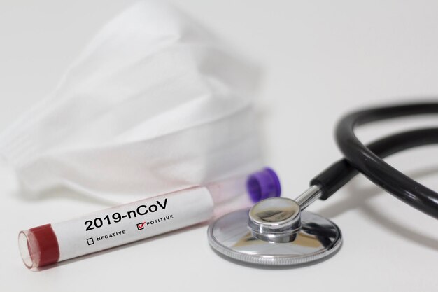 테이블에 스테토스코프와 얼굴 마스크로 코로나19 혈액 검사
