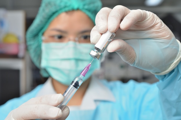 Covid-19 coronavirusvaccin in dokter Onderzoeker wetenschapper handen op schouder met spuit en fles met vaccin voor coronavirus. Gezondheidszorg, medisch, laboratoriumconcept.