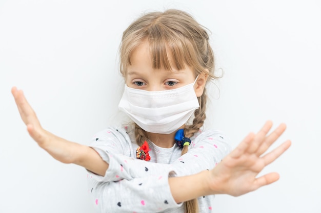 Covid-19 en luchtvervuiling pm2.5 concept. Klein meisje dat een masker draagt om pm2.5 te beschermen en een handgebaar om de uitbraak van het corona-virus te stoppen.