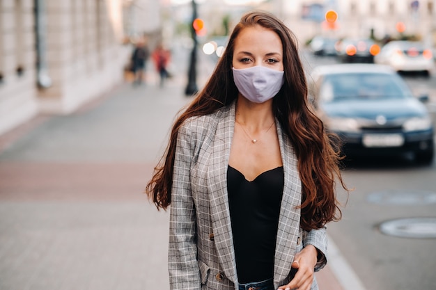 Covid-19 en luchtvervuiling pm2.5-concept. Pandemie, portret van een jonge vrouw die beschermend masker op straat draagt. Concept gezondheid en veiligheid.