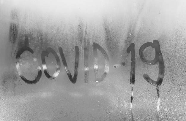 Covid 19 inscription on the foggy window