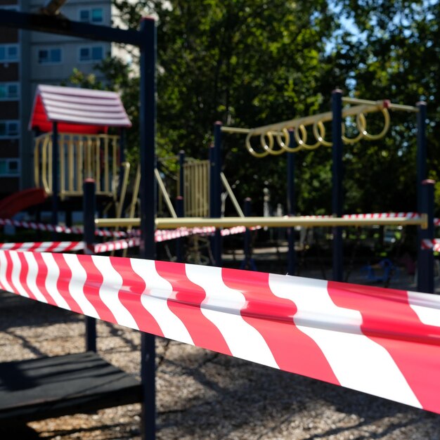 Photo covid 19 lockdown red and white tape around playground