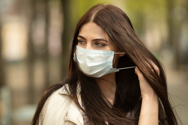 COVID-19 Pandemisch coronavirus Vrouw op straat met gezichtsmasker beschermend voor verspreiding van ziektevirus. Meisje met beschermend masker op gezicht tegen de ziekte van Coronavirus 2019.