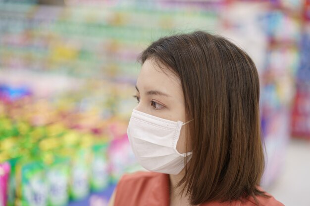 Covid-19の大流行。食品を買う医療防護マスクパニックの女性。コロナウイルスの恐怖。