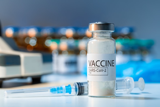 Covid-19 vaccine bottle with a syringe on lab table