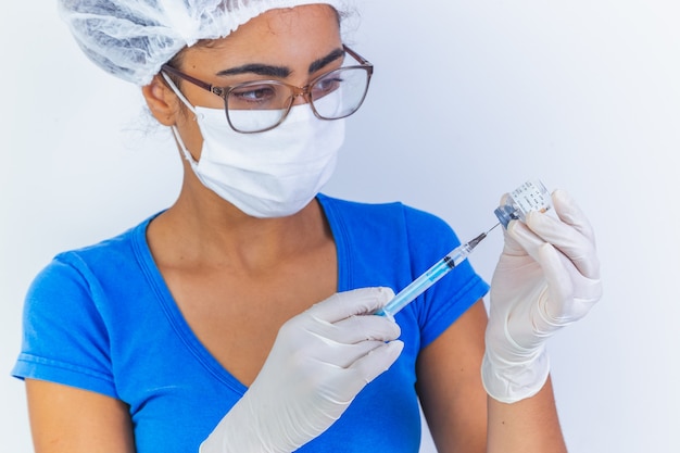 COVID-19 vaccine in researcher hands, female doctor holds syringe and bottle with vaccine for coronavirus cure. Concept of corona virus treatment, injection, shot and clinical trial during pandemic.