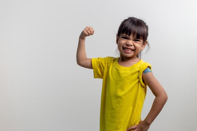 COVID 19 Vaccines for Kids concept Studio een portret van een schattig Aziatisch meisje na het krijgen van zijn eerste dosis vaccin Immuunveilig Beschikbaar Terug naar school