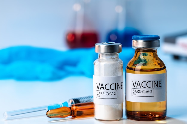 Covid-19 vaccinfles met een spuit op laboratoriumtafel