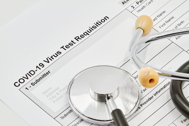 COVID-19 Virus test Requisition form with stethoscope on it. Closeup.