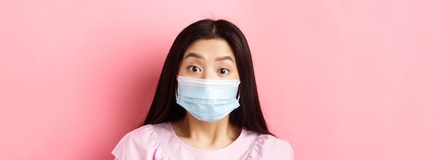 사진 코비드와 건강한 사람들은 의료용 마스크를 쓴 놀란 아시아 소녀의 근접 촬영 초상화를 개념화했습니다.