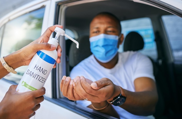 Covid cleaning and hygiene at drive thru testing centre or station for coronavirus African man driving his car and wearing protective face mask to avoid contact with medical worker