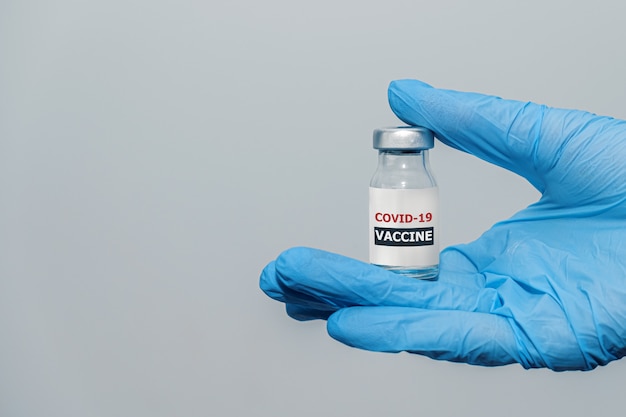 Covid-coronavirusvaccin in de hand van de arts met beschermende handschoenen