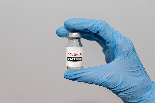 Covid coronavirusvaccin in de hand van de arts met beschermende handschoenen