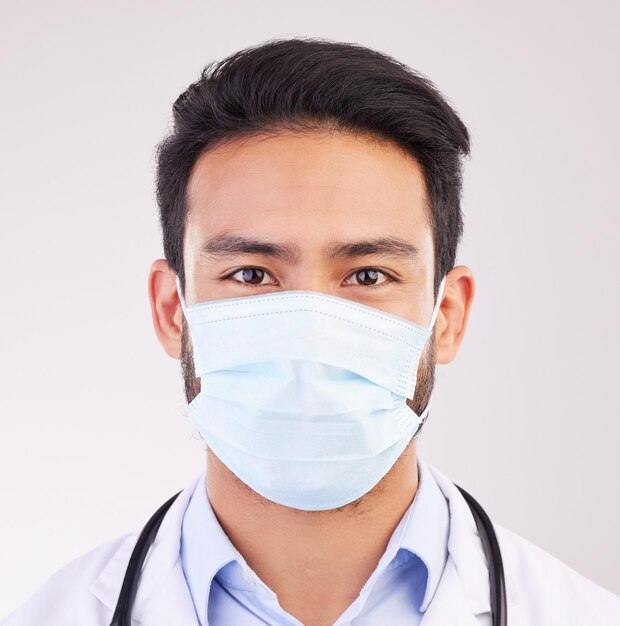 Photo covid doctor and portrait of man in studio with protection safety or corona compliance on white background face mask and male healthcare worker at hospital for treatment and disease prevention