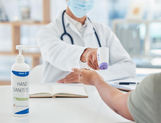 Covid doctor and thermometer for a safety hygiene check with a patient during corona virus in hospital Closeup hands of healthcare workers doing wellness service test for fever during consultation