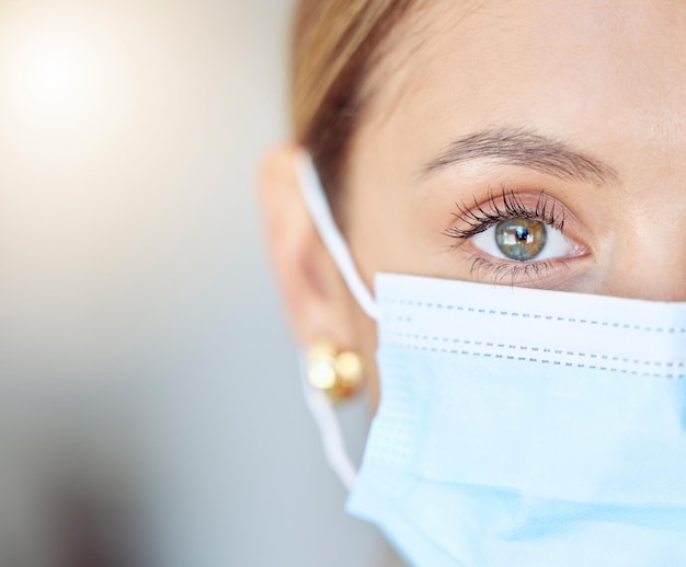 Covid gezondheidsgezichtsmasker en mensheid met close-up van oog van jonge vrouw die beschermingsvoorzorg en veiligheid draagt Portret van een vrouw en gezondheidszorg tegen coronavirusgriep en verkoudheid in een pandemie