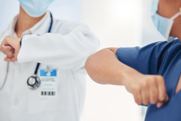 Covid handshake of a nurse and doctor as a surgery success welcome or support gesture Medical and healthcare workers working in a hospital wellness clinic of doctors office greeting at work