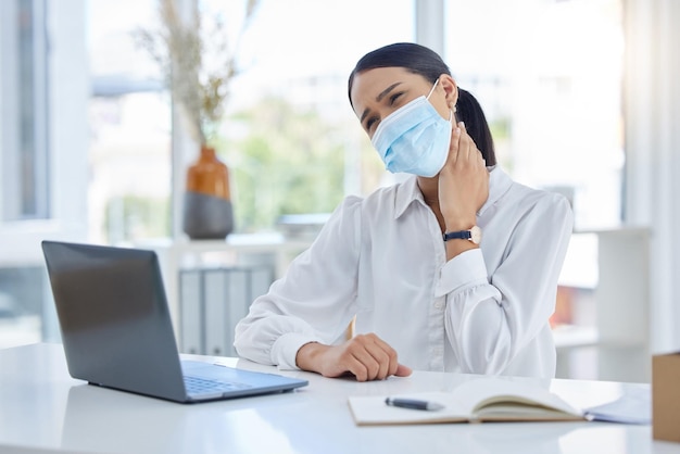 Covid-nekpijn en een vrouw met laptop en gezichtsmasker op kantoor Online overuren en een vermoeide zakenvrouw aan een bureau met hand in nek Stressletsel en angst dame aan het werk tijdens pandemie