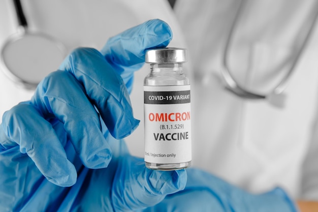 Covid ommicron variant vaccin in de hand op de witte achtergrond