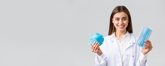Covid-preventie van virusgezondheidswerkers concept glimlachend aantrekkelijke vrouwelijke arts in witte scrubs s
