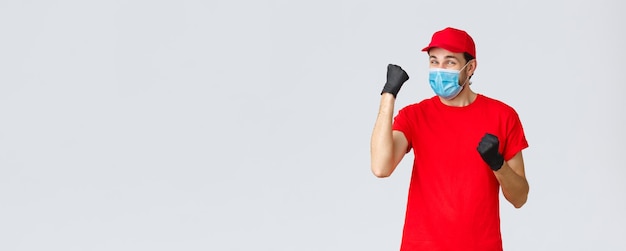 Covid selfquarantine online shopping and shipping concept cheerful delivery man in red uniform glove...