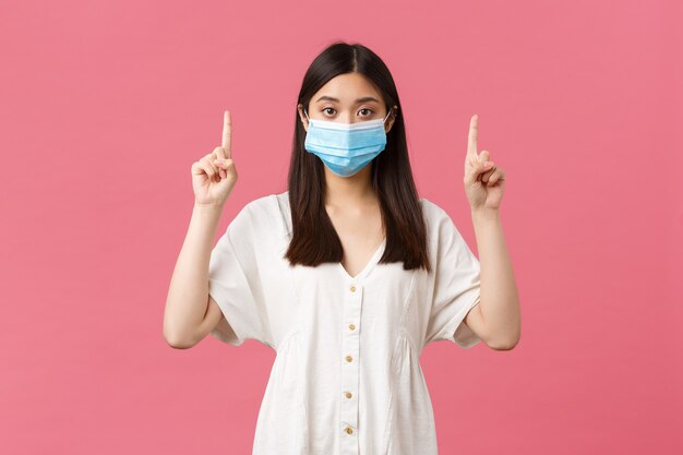 Covid social distancing virus and lifestyle concept pretty stylish asian girl in medical mask sugges...