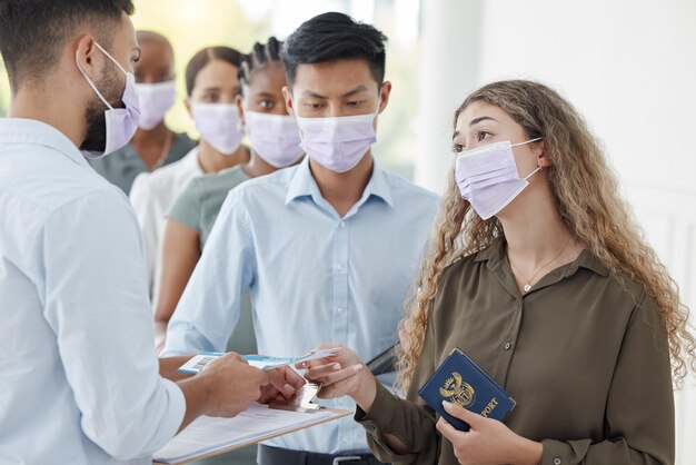 搭乗のためのセキュリティでチェックインする身分証明書に沿った女性乗客とのCovid旅行と空港 チケットの制限とマスクを着用した女性旅行者の安全