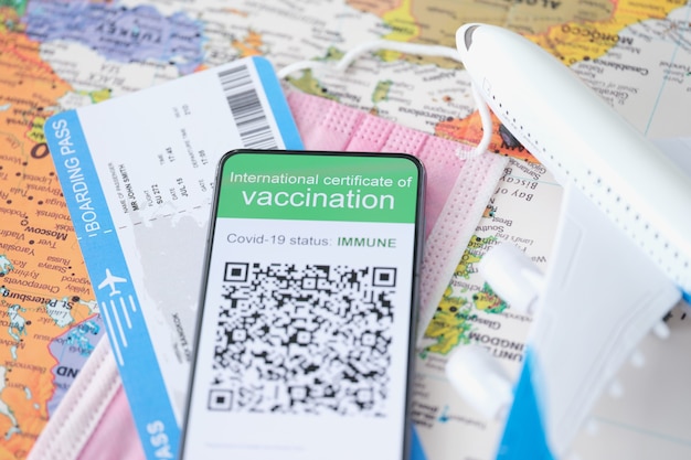 Covid vaccinatiepaspoort wordt weergegeven op smartphone naast vliegticket vaccinatieziekte