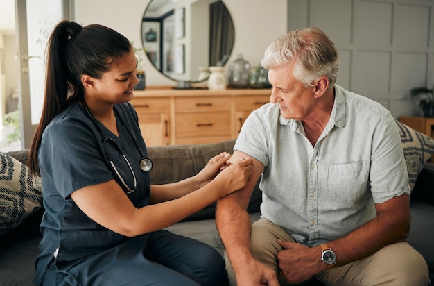 Covid-vaccinverpleegkundige en oudere man helpen bij het raadplegen en praten over gezondheid in de woonkamer thuis Gezondheidszorg volwassen man en patiënt met arts of medische professional in de lounge op de bank test