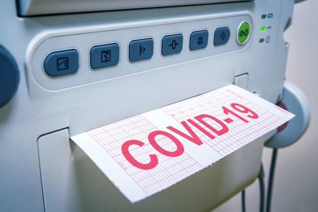 Концепция коронавируса COVID19 медицинское оборудование для диагностики в больнице или клинике машина и бумага с надписью COVID