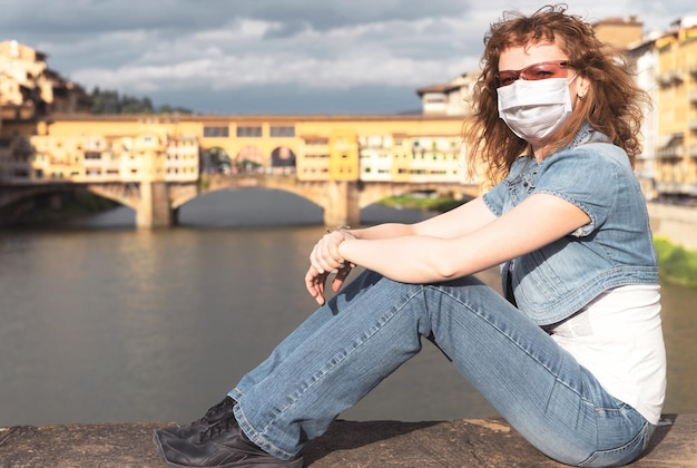 COVID19 coronavirus in Italy young woman in face medical mask in Florence street Tourist landmarks closed due to corona virus outbreak