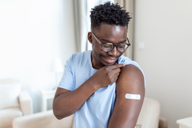 Covid19 Vaccination Portrait Of Happy Vaccinated African Man Showing His Arm After Coronavirus Antiviral Vaccine Shot  Covid Immunization Campaign Concept