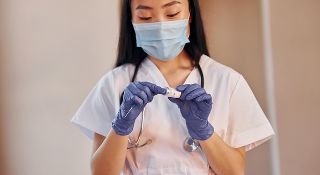 COVID19 vaccine Young serious asian woman standing indoors