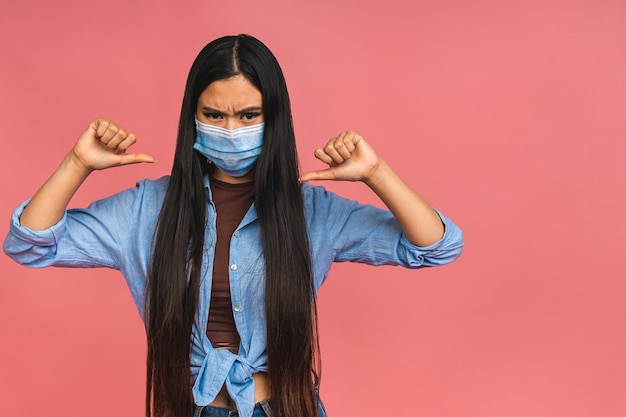写真 covid19ウイルスの健康と医学のコンセプトピンクの背景に隔離されたコロナウイルス検疫中に医療用保護マスクを着用したアジアの若い女性のポートレート