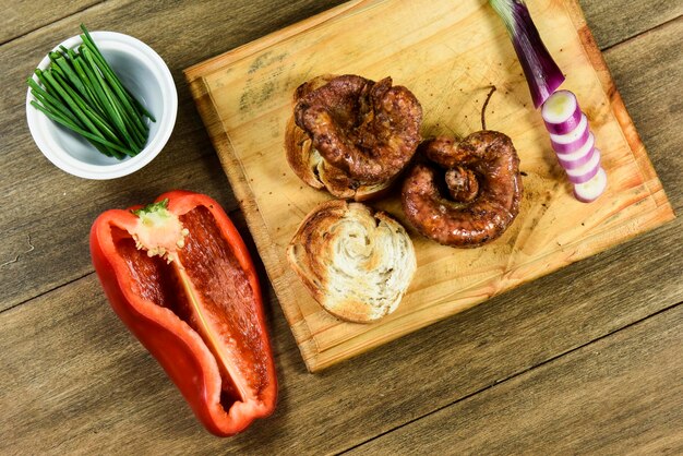 Cow bowels presented on a wooden board with ingredients ready to grill