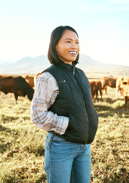肉牛や牛の食品産業のための自然の草原にいる牛の農家とアジアの女性牛の家畜と農業動物の牛乳の生産と成長のための幸せな笑顔と農業の成功
