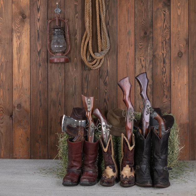 Photo cowboy hat boots and gun on a wooden floor