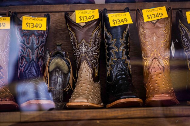 Foto cowboy laarzen en lederen riemen in een zakelijke vitrine zadelschoenen en accessoires