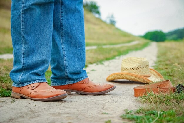 A Cowboy legs in shoes in the park on nature background The man at the ranch