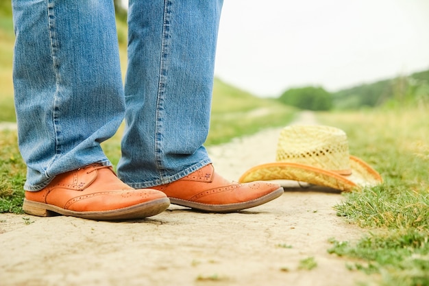 A Cowboy legs in shoes in the park on nature. The man at the ranch.