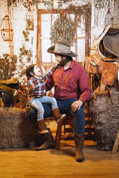 cowboy man next to his daughter with red shirt on cowboy stage