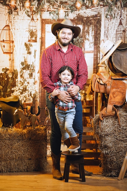 cowboy man next to his daughter with red shirt on cowboy stage