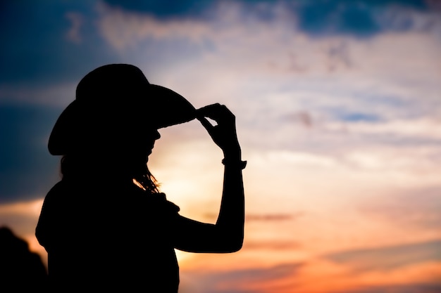 Cowboy meisje silhouet op zonsondergang