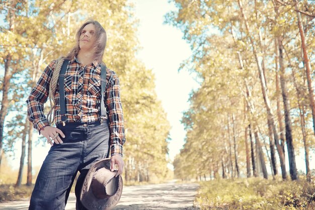 Cowboy with hat in a field in autumn