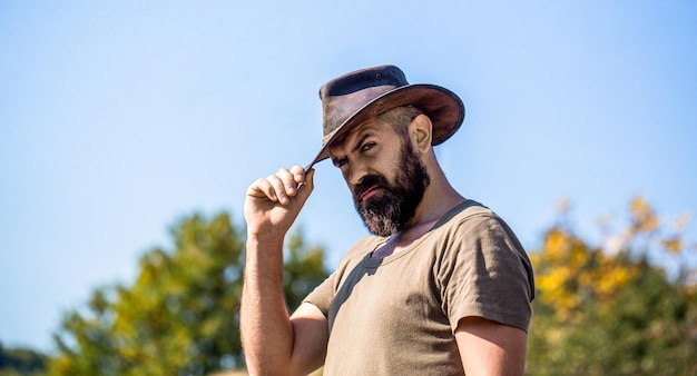 Cowboyhoed Portret van een jonge man die een cowboyhoed draagt Cowboys in een hoed Mooie baardige macho